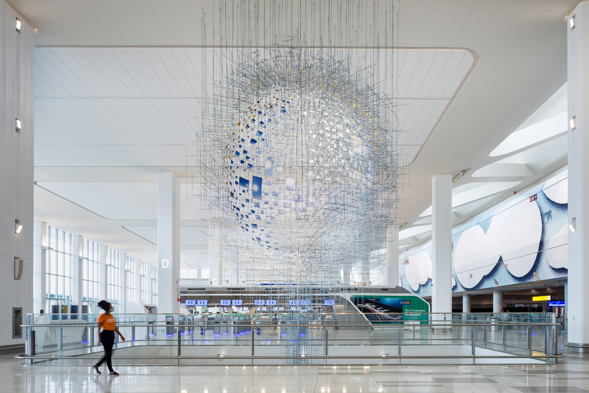 An intricate constellation of hundreds of photographs forming a mirage-like sphere that appears to float in midair.