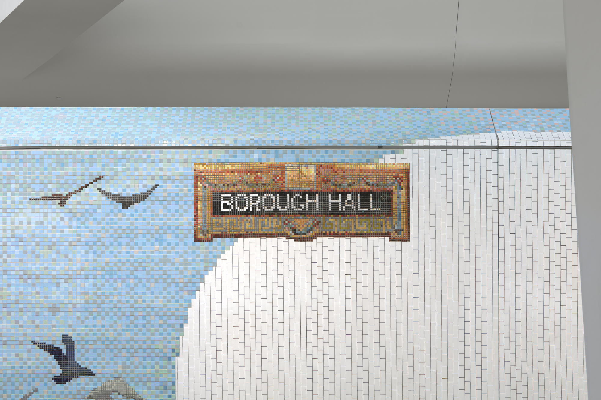 A tiled mosaic of a sign that says borough hill floating against a light blue background with the edge of a large cloud on the top left.