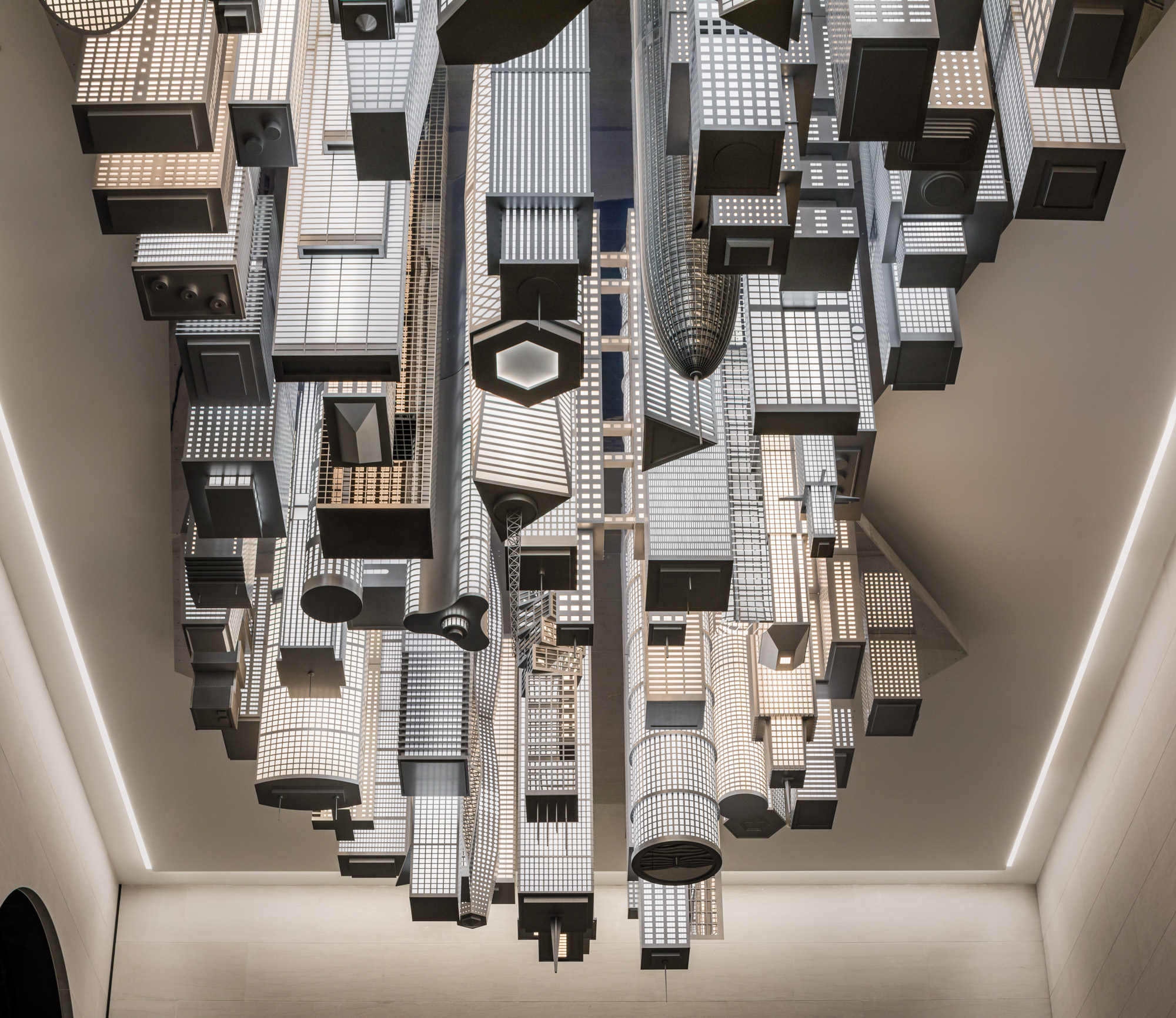 A close-up shot of a crop of black and white lit up high-rise buildings descending from the ceiling.