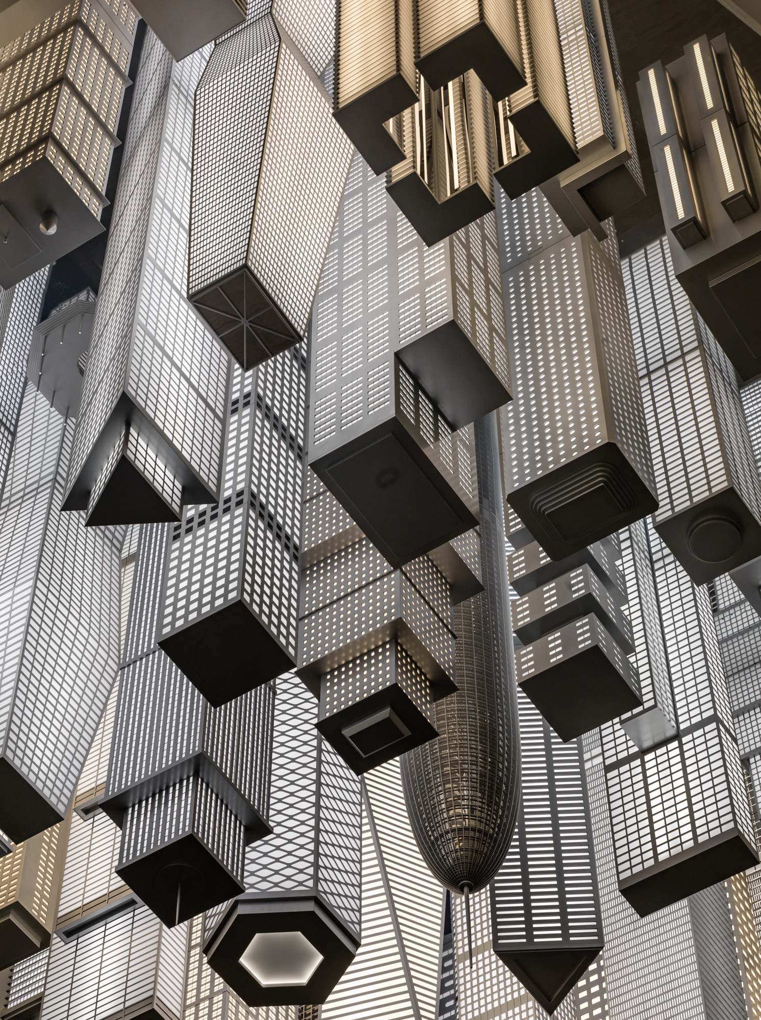 A close-up shot of a crop of black and white lit up high-rise buildings descending from the ceiling.