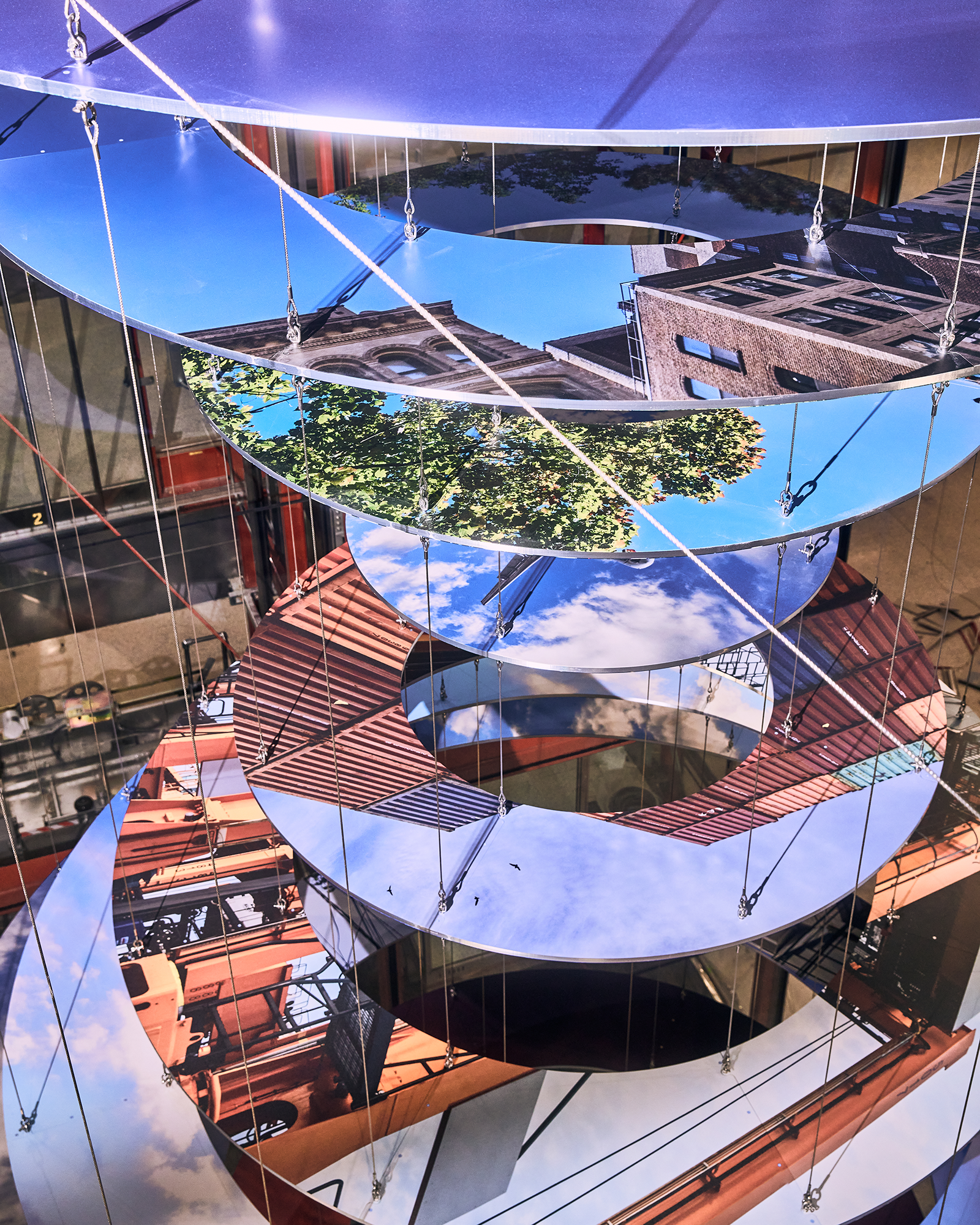 Slices of New Jersey skyline photographs are suspended in two large helix-like structures, hanging from the inside of an airport terminal.