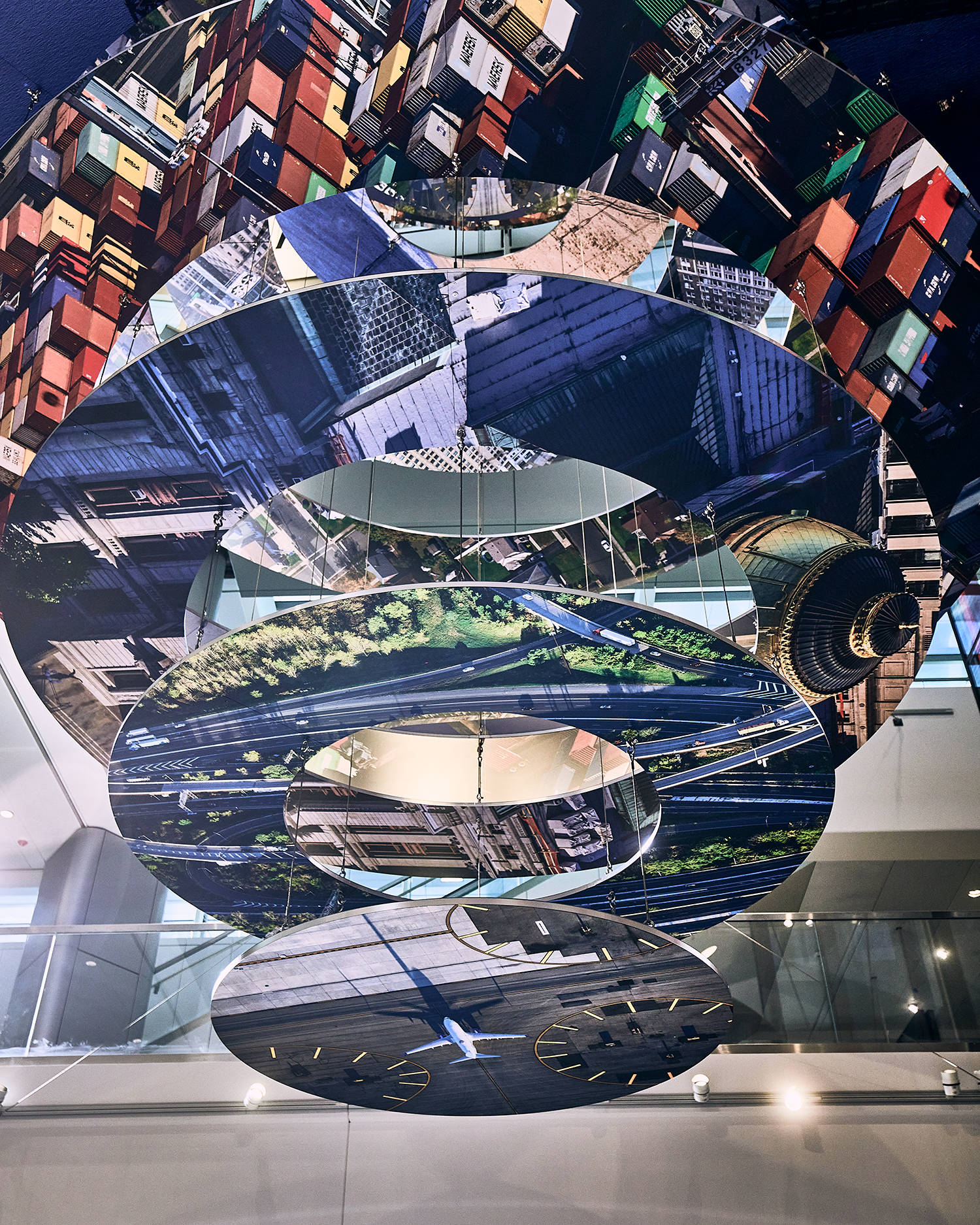 Slices of New Jersey skyline photographs are suspended in two large helix-like structures, hanging from the inside of an airport terminal.