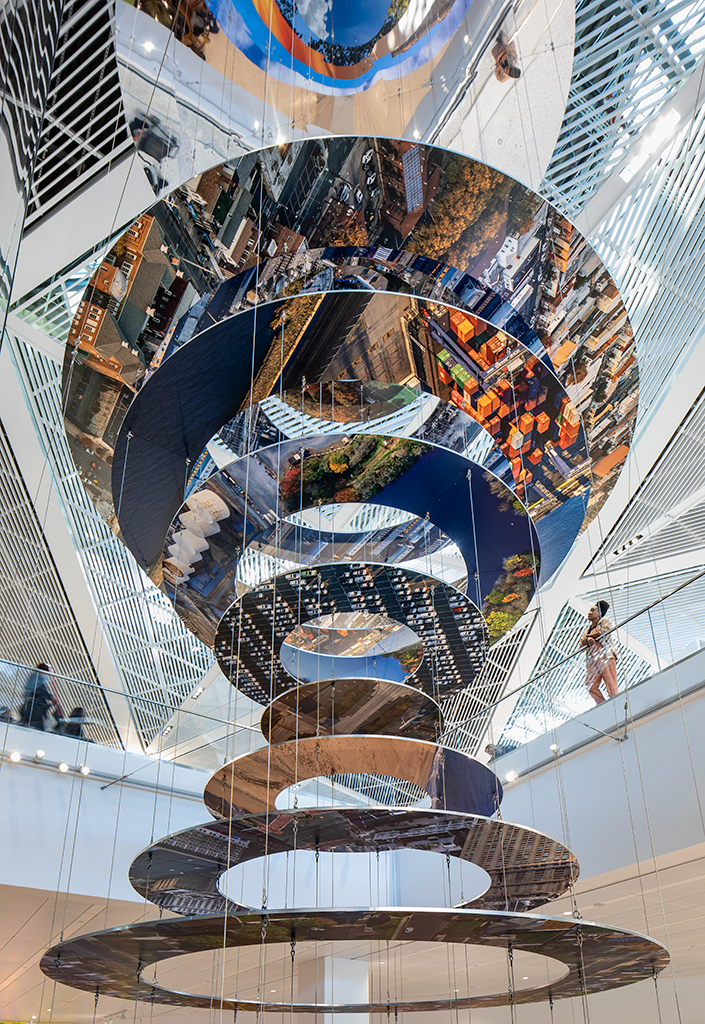 Slices of New Jersey skyline photographs are suspended in two large helix-like structures, hanging from the inside of an airport terminal.