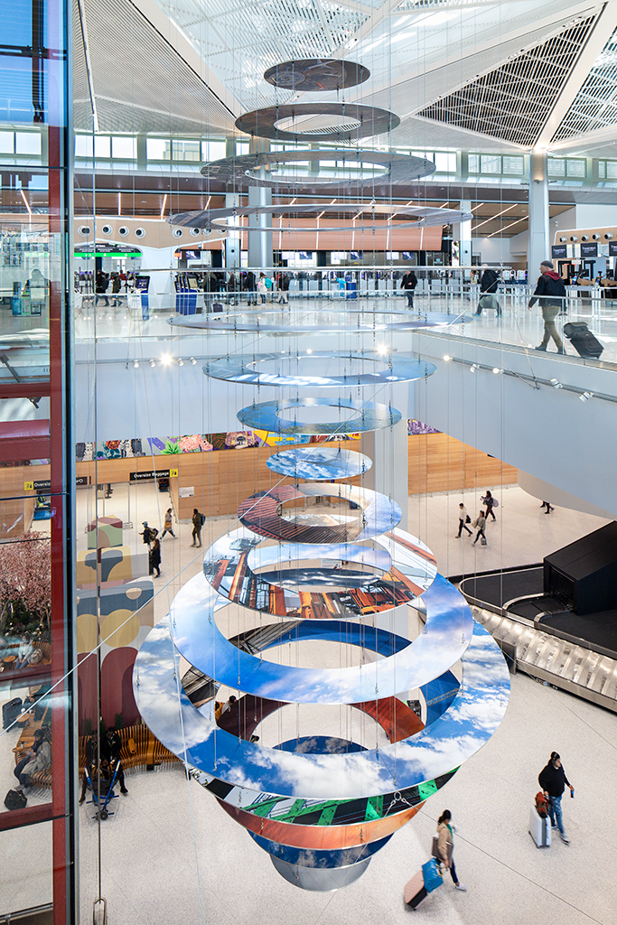Slices of New Jersey skyline photographs are suspended in two large helix-like structures, hanging from the inside of an airport terminal.