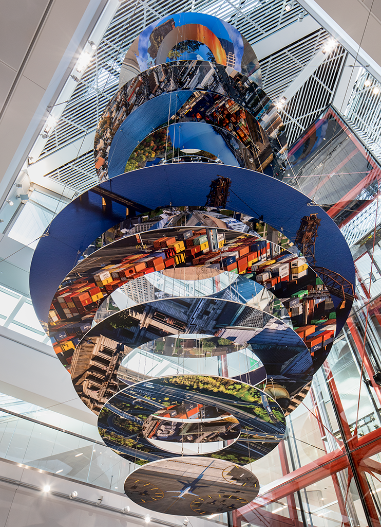 Slices of New Jersey skyline photographs are suspended in two large helix-like structures, hanging from the inside of an airport terminal.