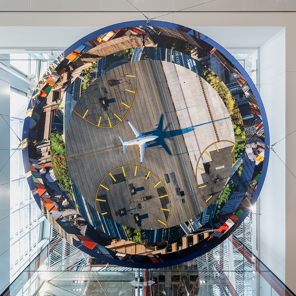 Slices of New Jersey skyline photographs are suspended in two large helix-like structures, hanging from the inside of an airport terminal.