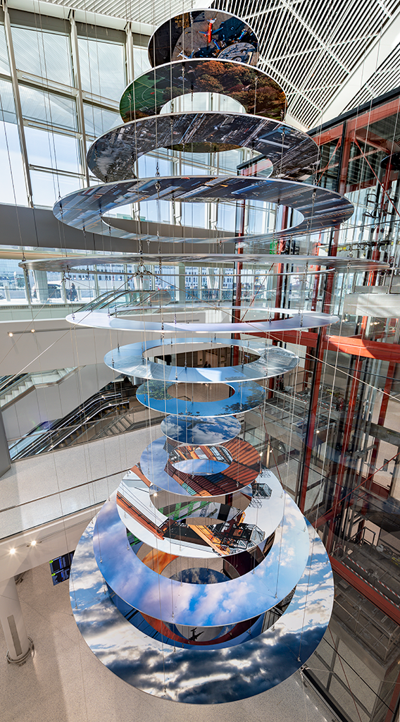 Slices of New Jersey skyline photographs are suspended in two large helix-like structures, hanging from the inside of an airport terminal.