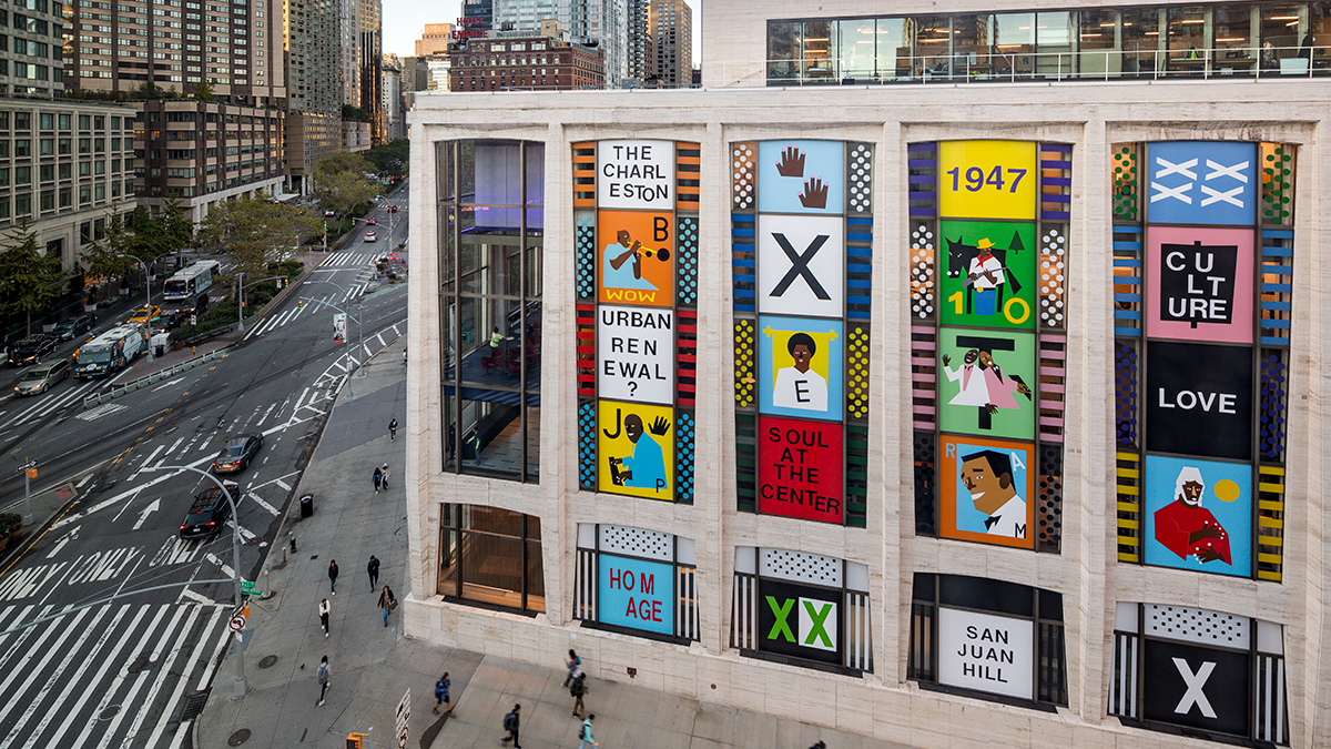 A composition of colorful, graphic portraits of significant San Juan Hill figures and historical references on the façade of a rectangular music hall in a bustling...